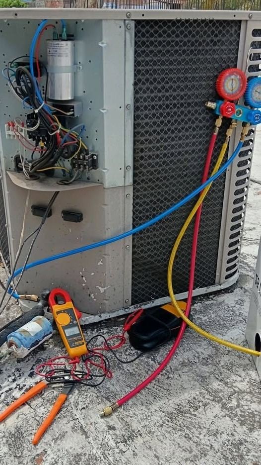 Gauges and multimeter on an air conditioning condenser during an AC repair in Greensboro NC